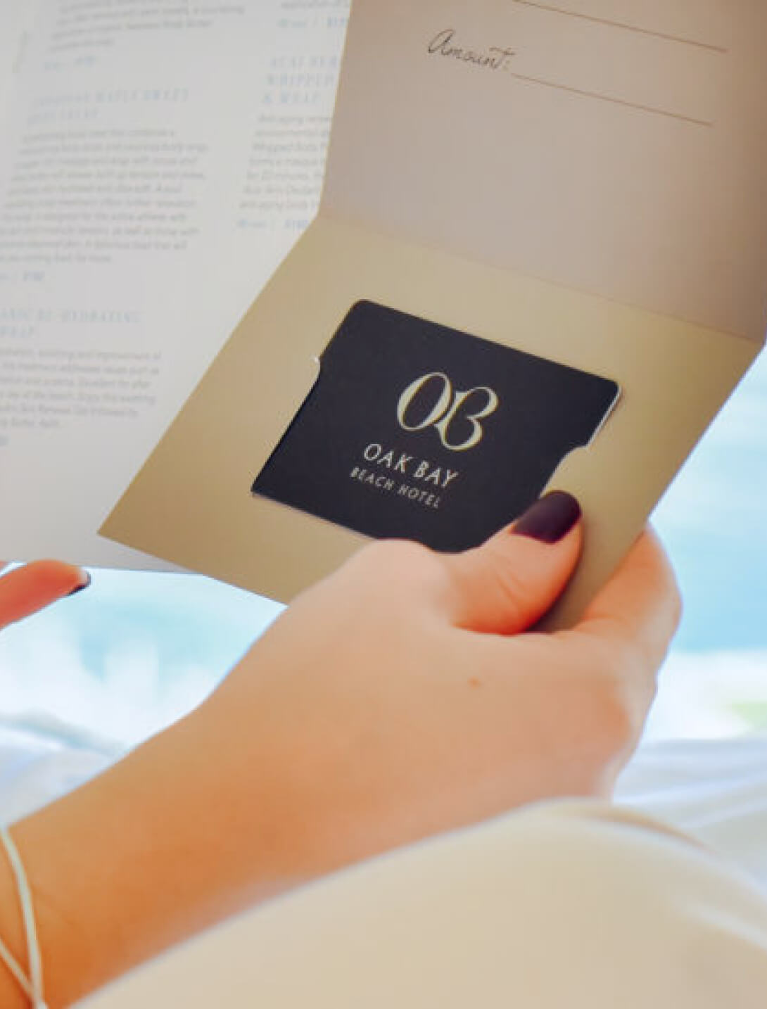 woman holding spa brochure and a oak bay beach hotel gift card