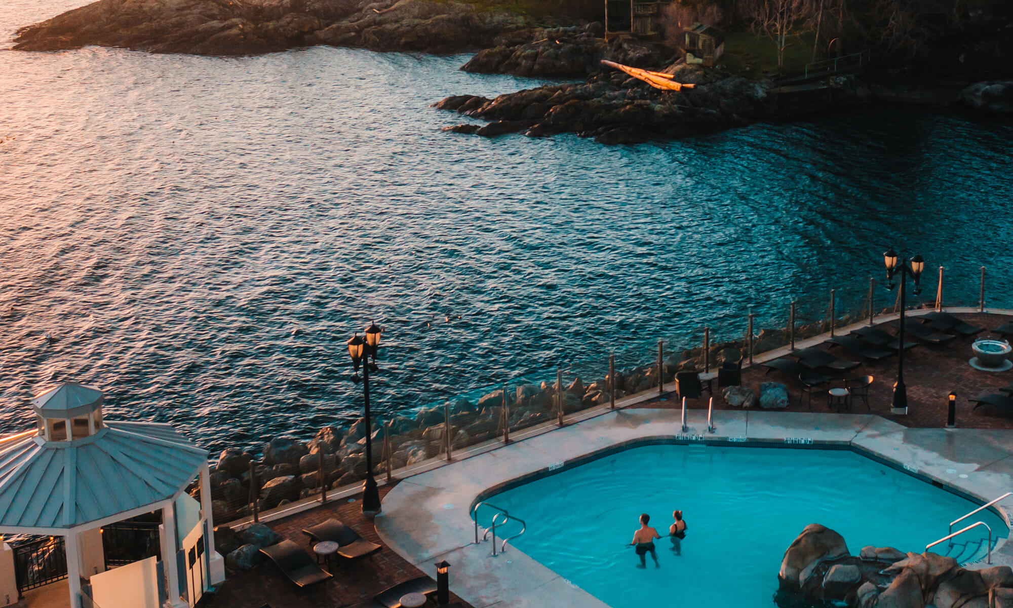 aerial view ocean front pool two people wadding viewing sunset