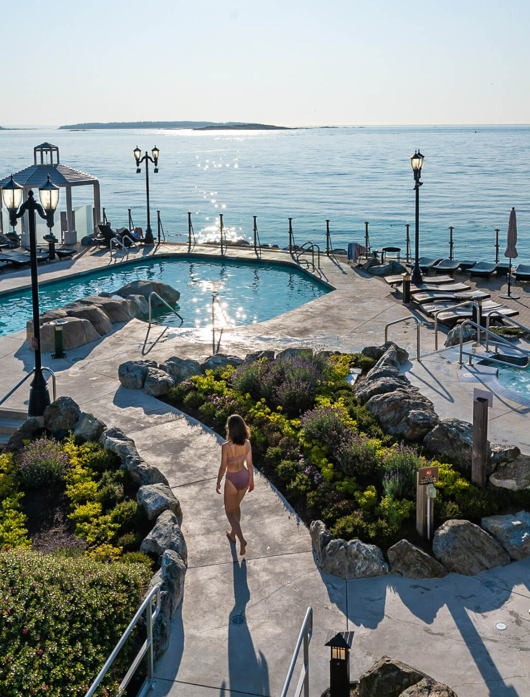 oceanfront views mineral pools woman walking on path in bathing suit immaculate landscaping