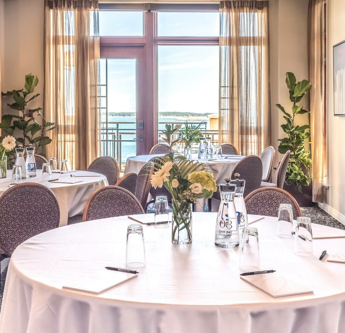 ocean view event space green florals pens on table rounds