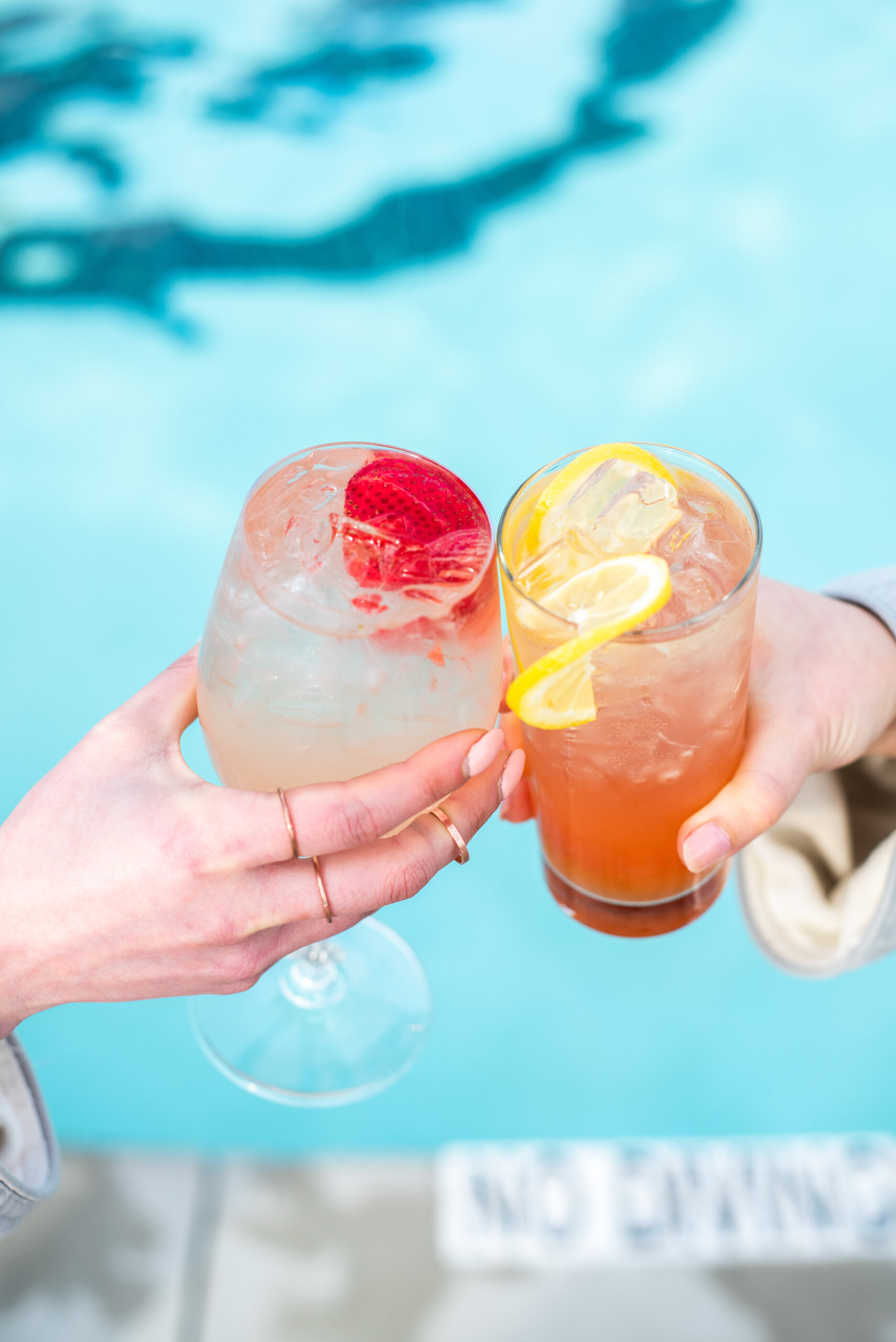 poolside drinks cheers tropical cocktails lemon twist strawberry garnish