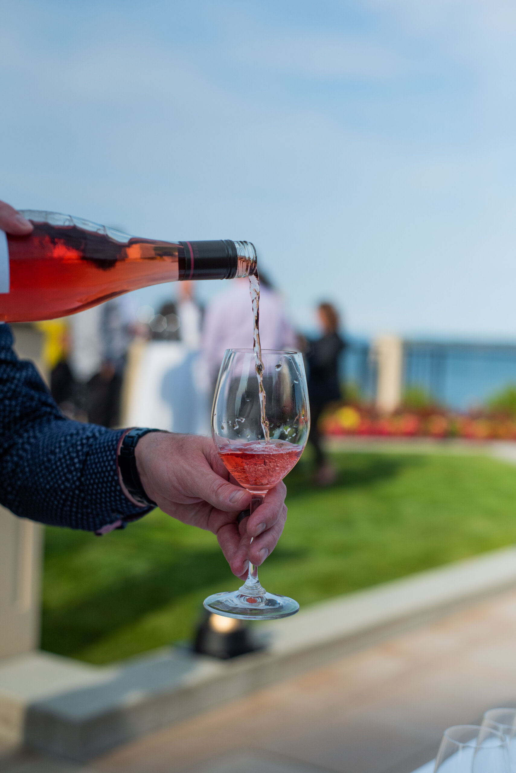 close-up pouring a glass of rose in the garden oceanside views