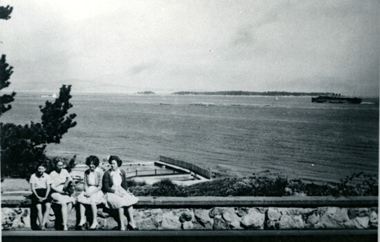 Group of young women sitting with ocean backdrop behind