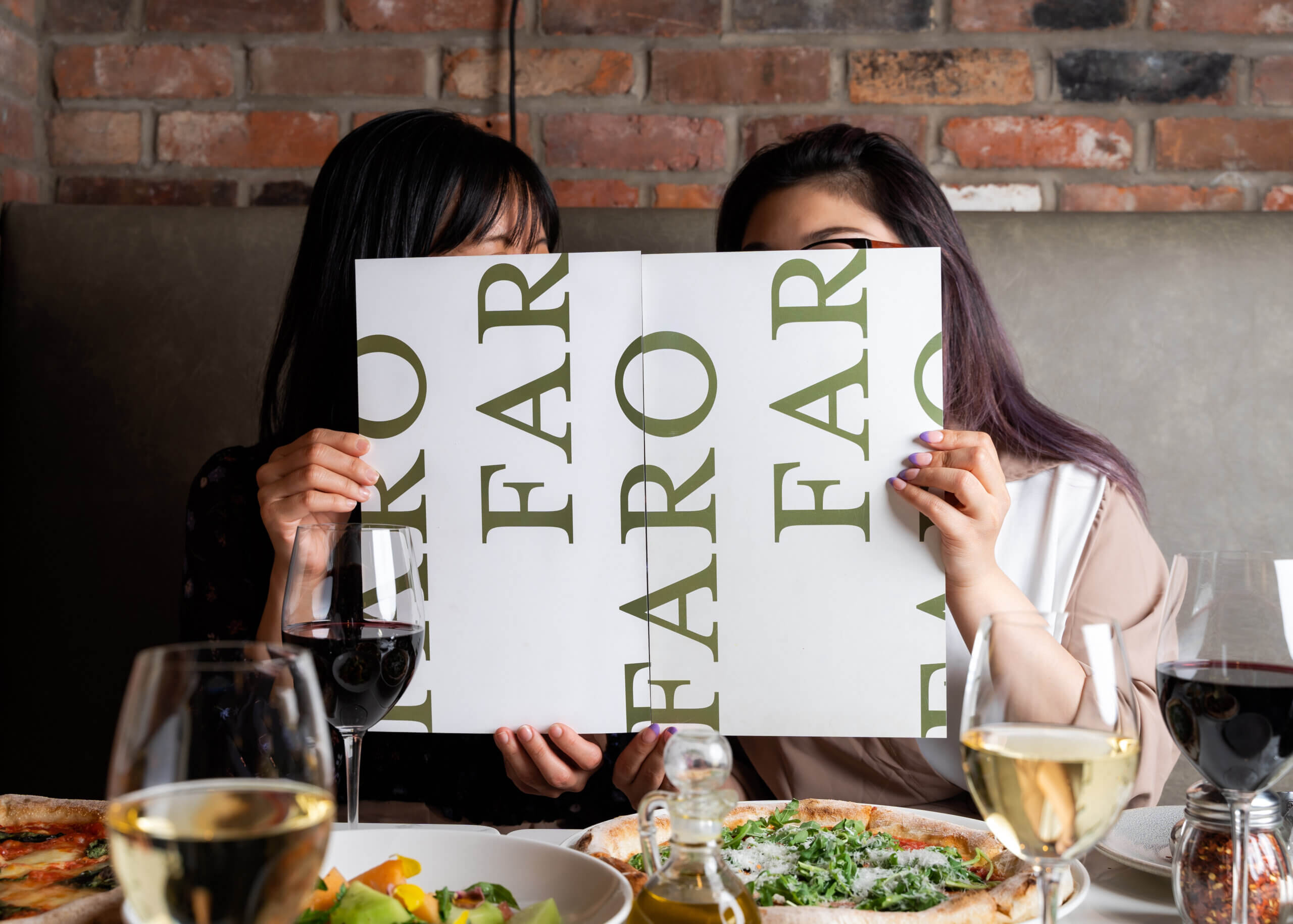 Women reading FARO Pizza menu